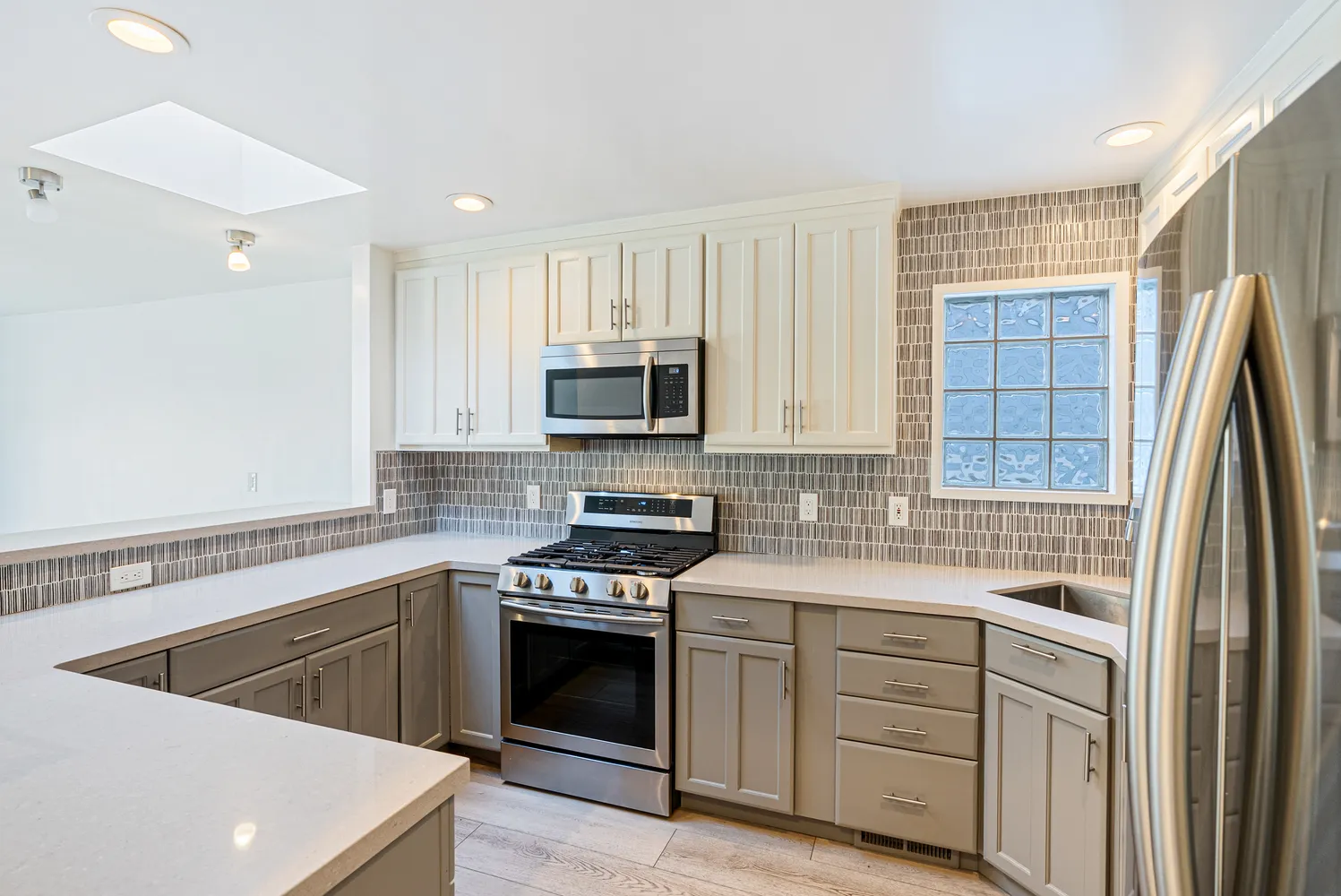 a kitchen with white cabinets sink and stainless steel appliances
