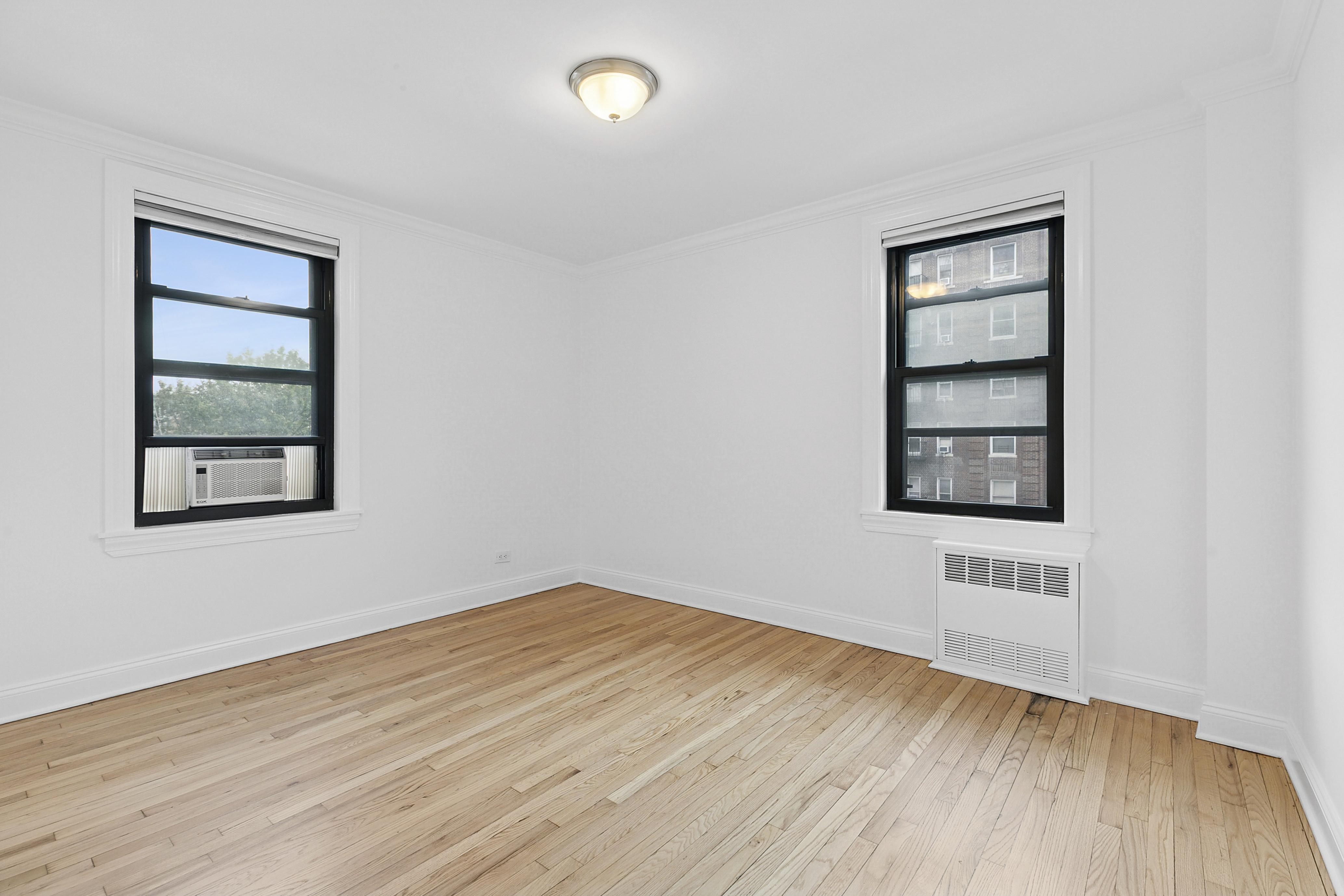 4501 Broadway, Unit 4G Manhattan, NY 10040 - Photo 6 of 7 an empty room with wooden floor and windows
