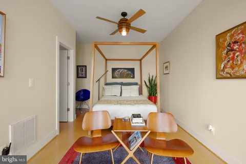 a bedroom with a bed a couch and a window