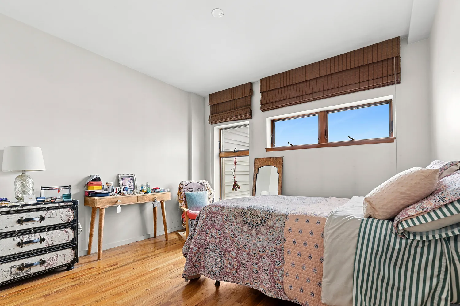 a bedroom with a bed and wooden floor