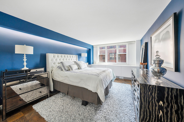 77 7th Avenue, Unit 9E Manhattan, NY 10011 - Photo 4 of 9 a bedroom with a bed a mirror and a night stand