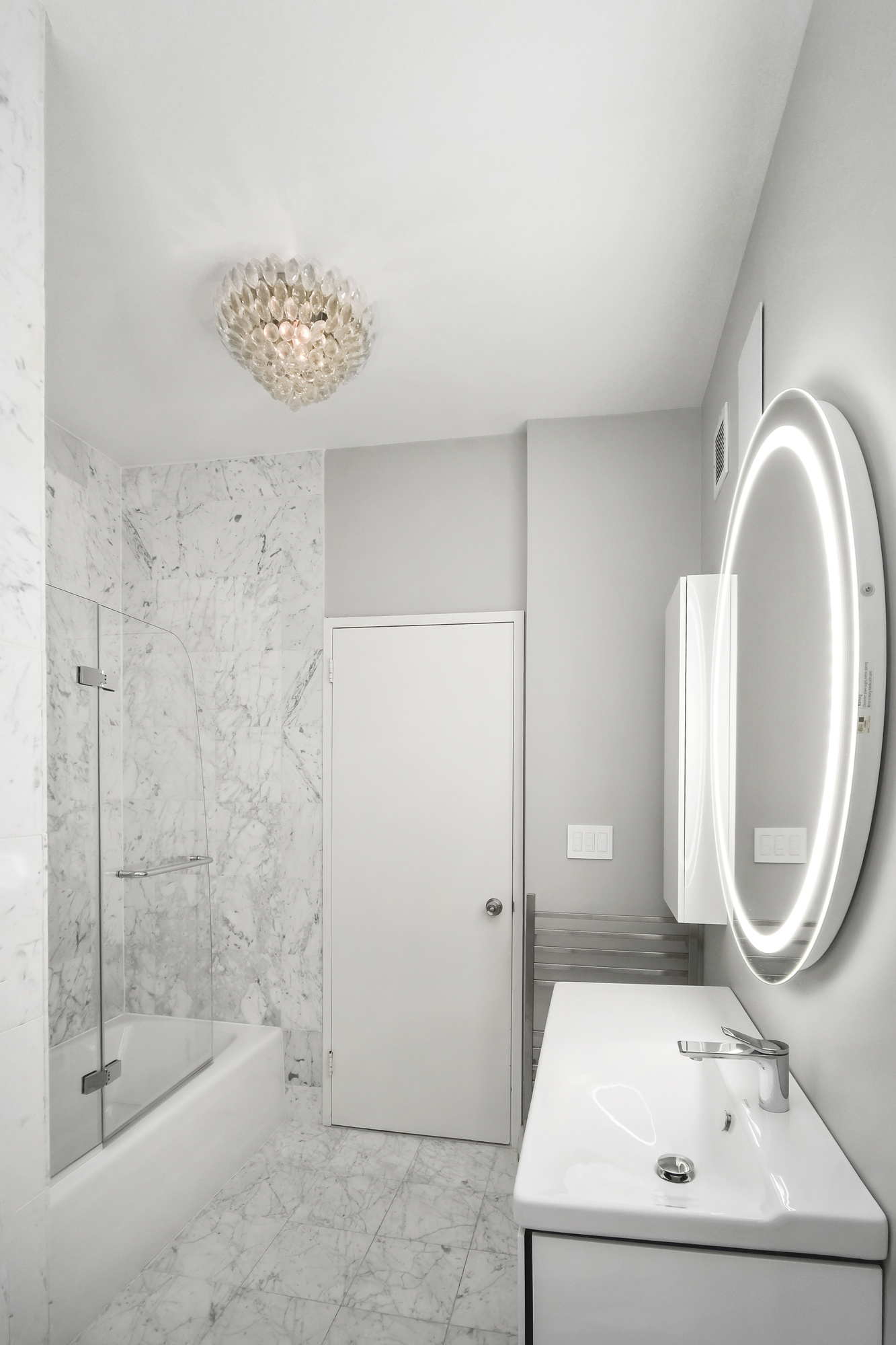 167 East 61st Street, Unit 23D Manhattan, NY 10065 - Photo 5 of 13 a bathroom with a sink a toilet and a mirror