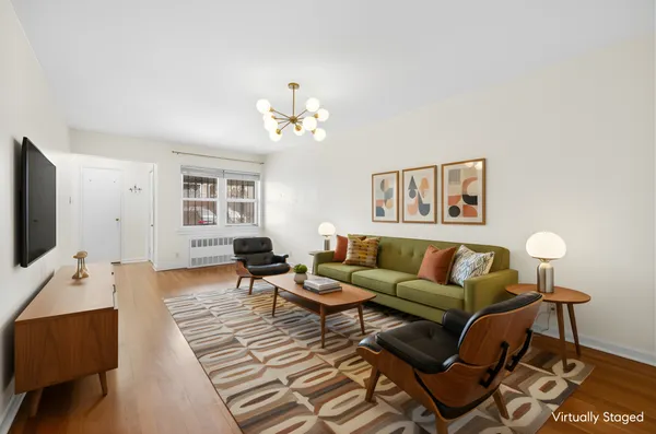 a living room with furniture a flat screen tv and a window