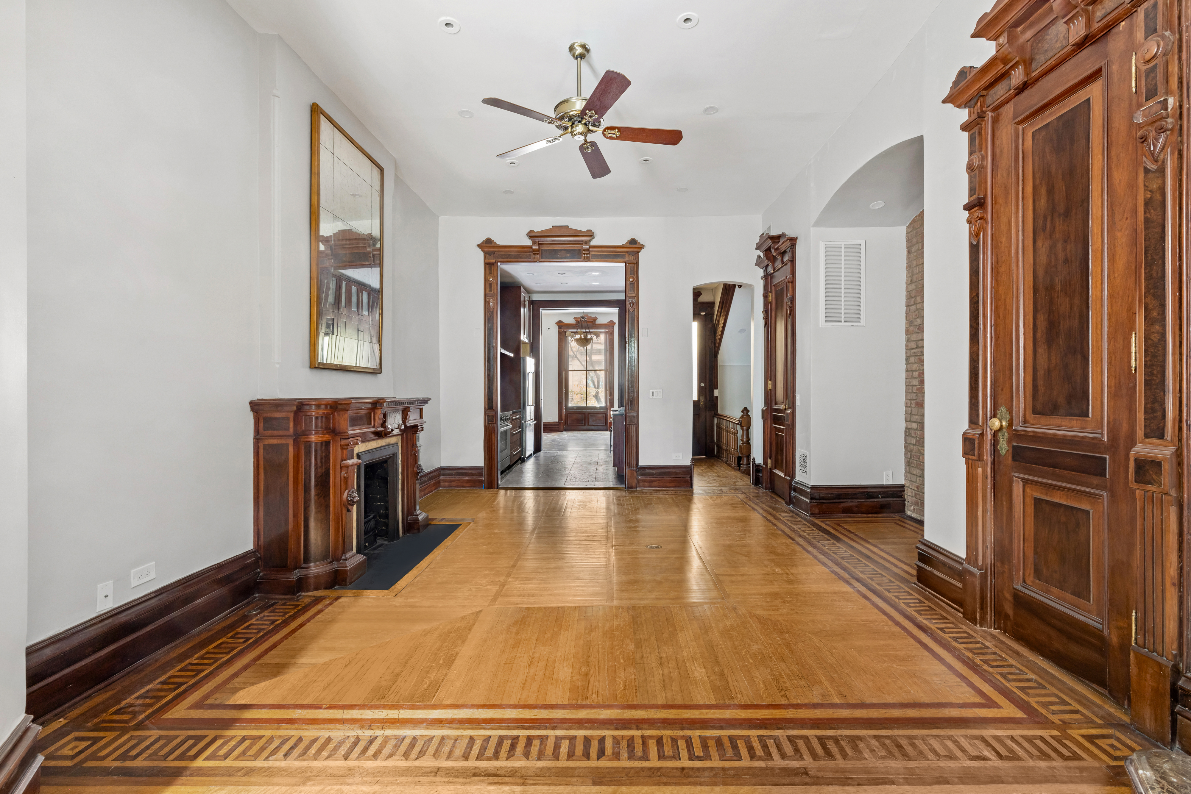 29 East 126th Street, Unit A Manhattan, NY 10035 - Photo 3 of 13 a view of a livingroom with a fireplace a ceiling fan and wooden floor