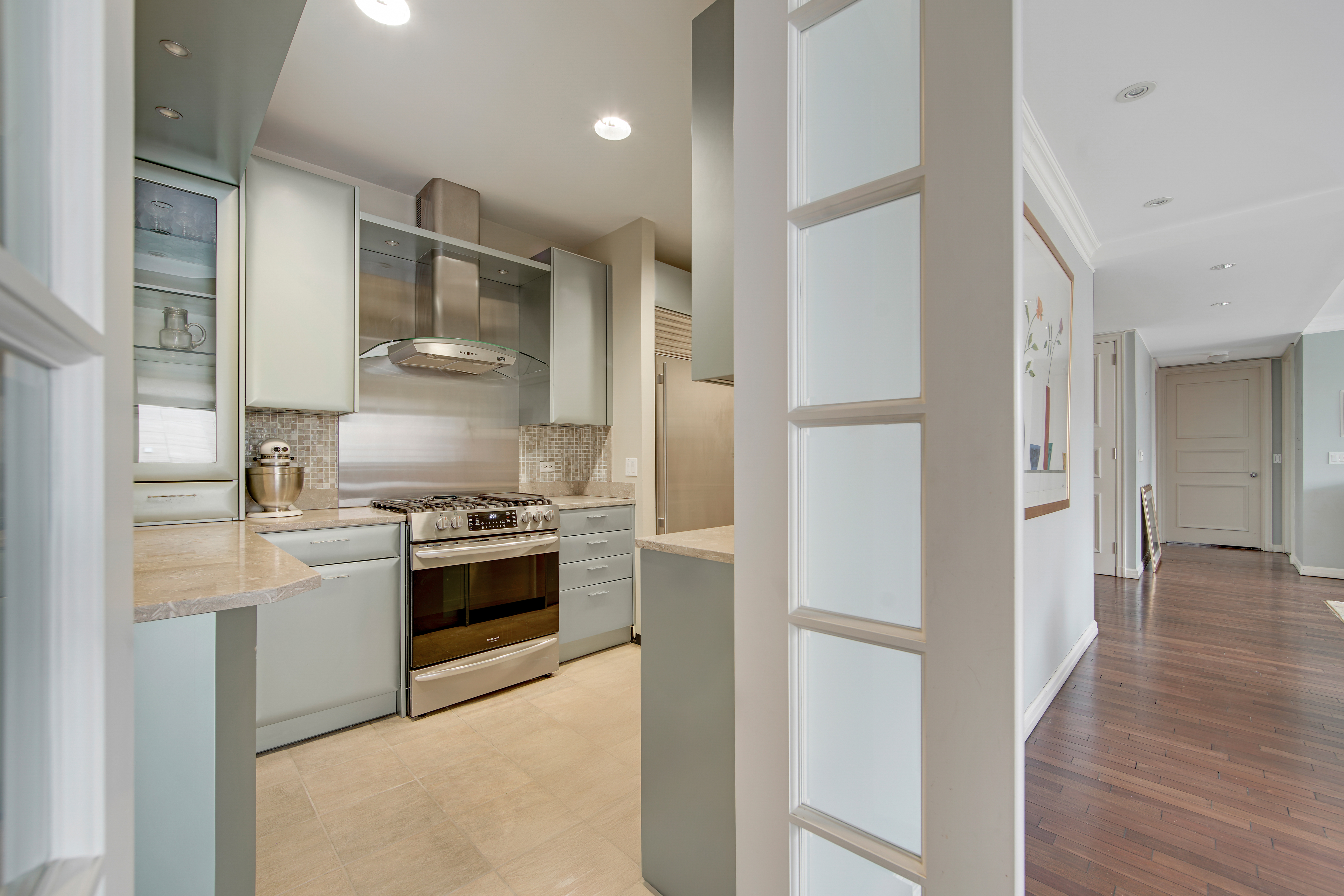 201 East 80th Street, Unit 16D Manhattan, NY 10075 - Photo 7 of 19 a kitchen with stainless steel appliances granite countertop a refrigerator and a stove