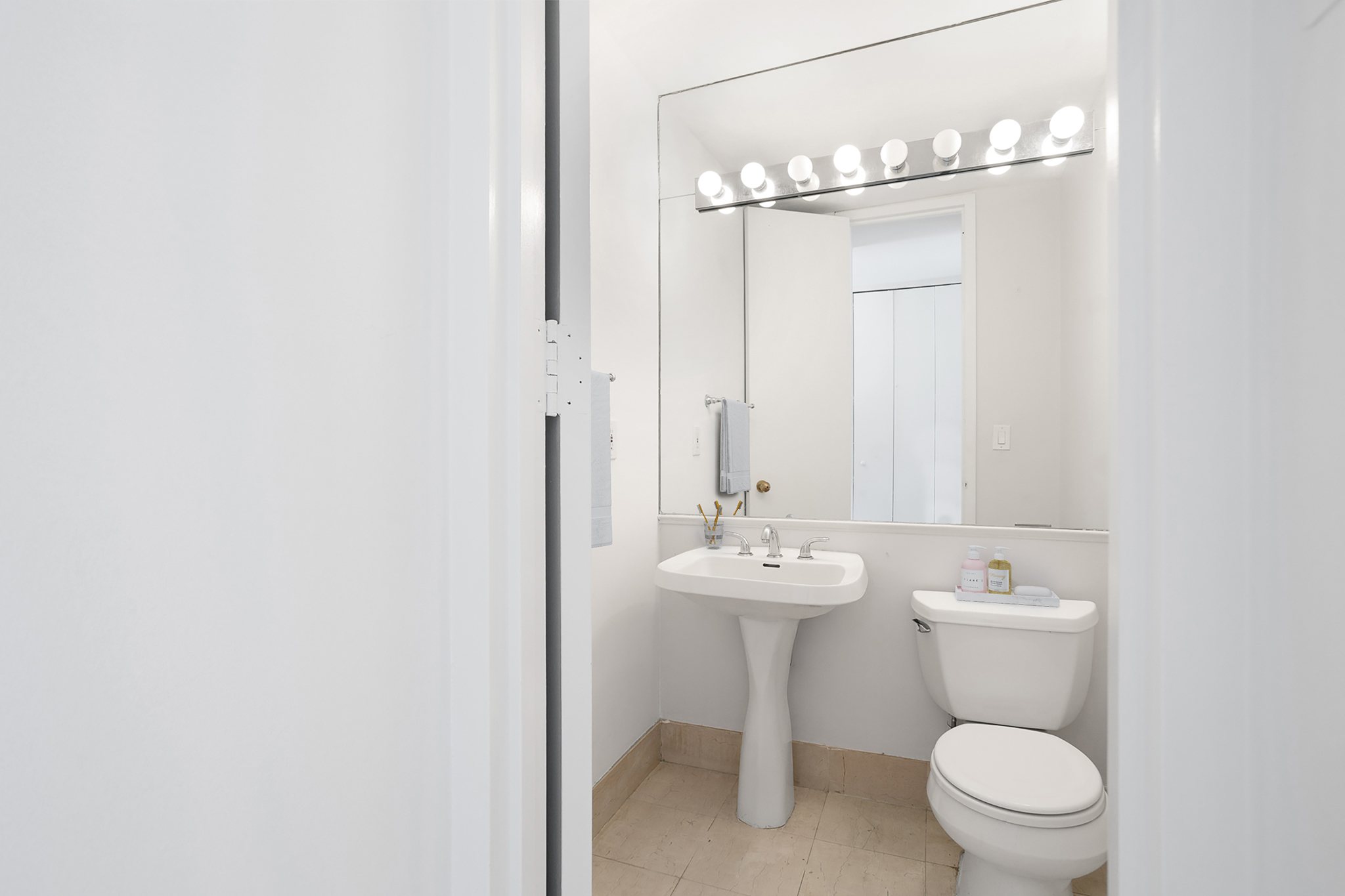 21 South End Avenue, Unit 406 Manhattan, NY 10280 - Photo 10 of 16 a bathroom with a toilet a sink and mirror