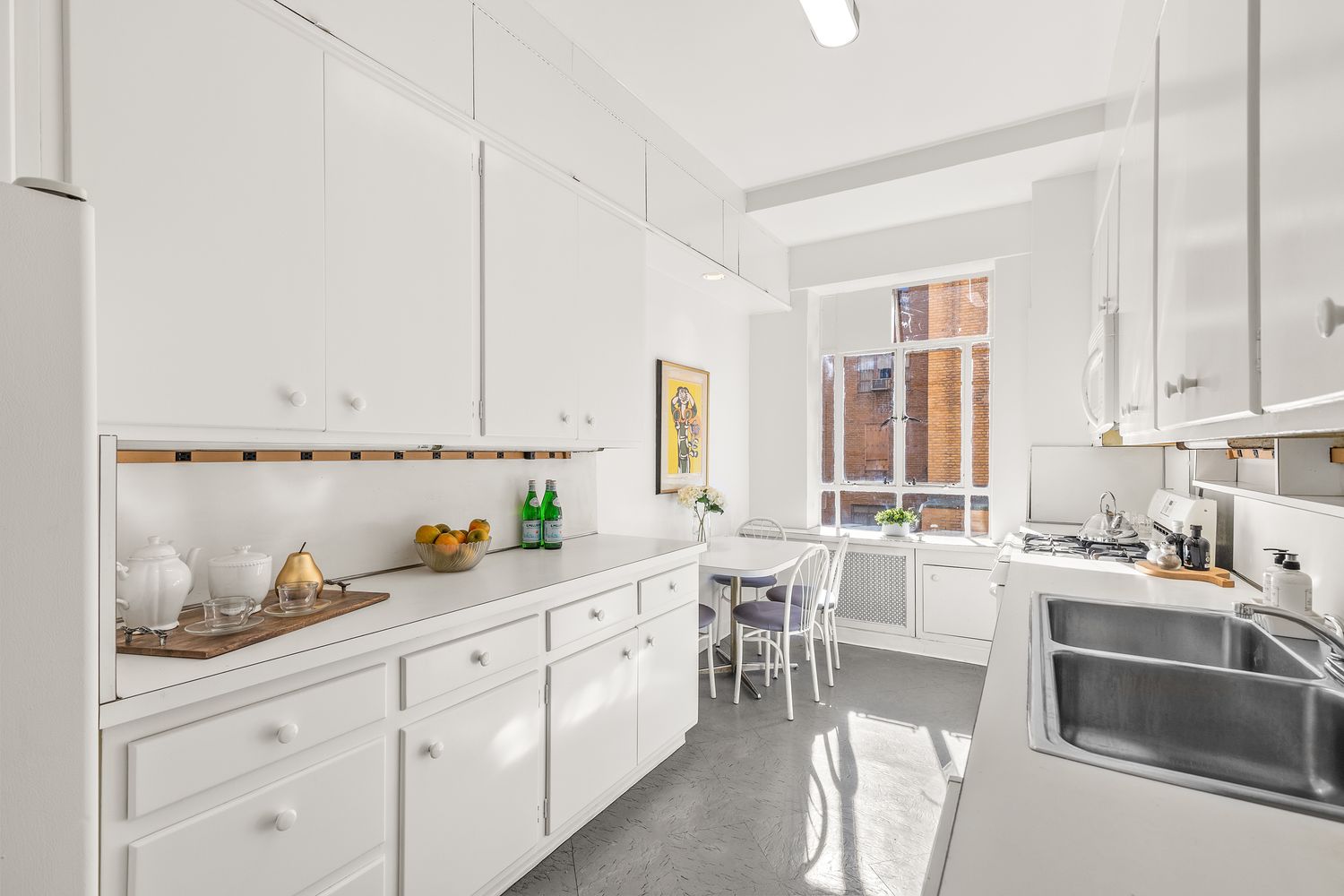 a kitchen with white cabinets and sink