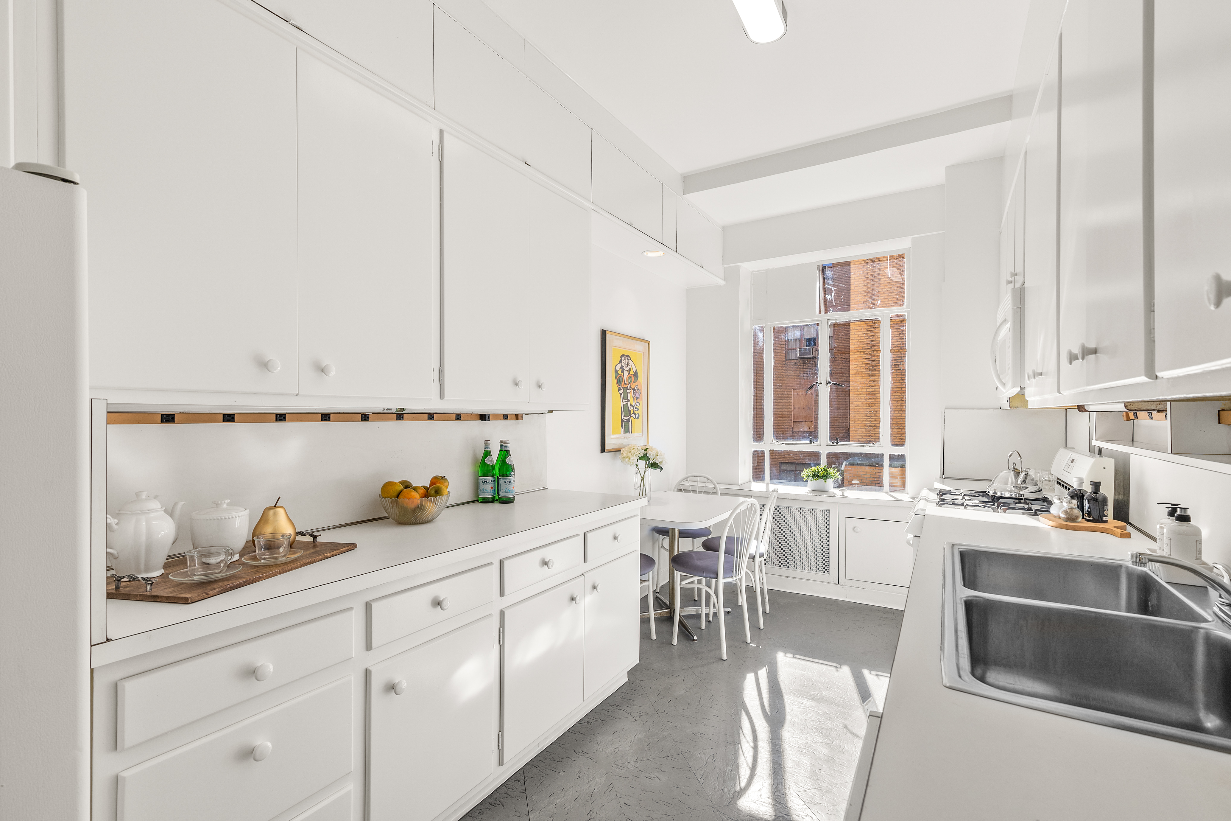 115 Central Park West, Unit 16H Manhattan, NY 10023 - Photo 21 of 30 a kitchen with white cabinets and sink