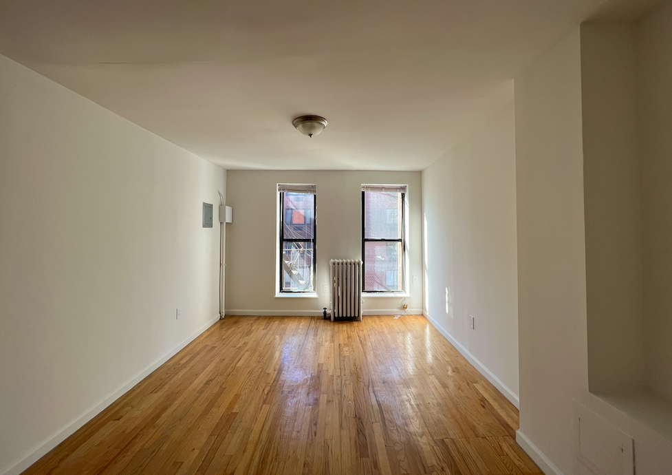 446 West 46th Street, Unit 16 Manhattan, NY 10036 - Photo 4 of 12 wooden floor in an empty room with a window
