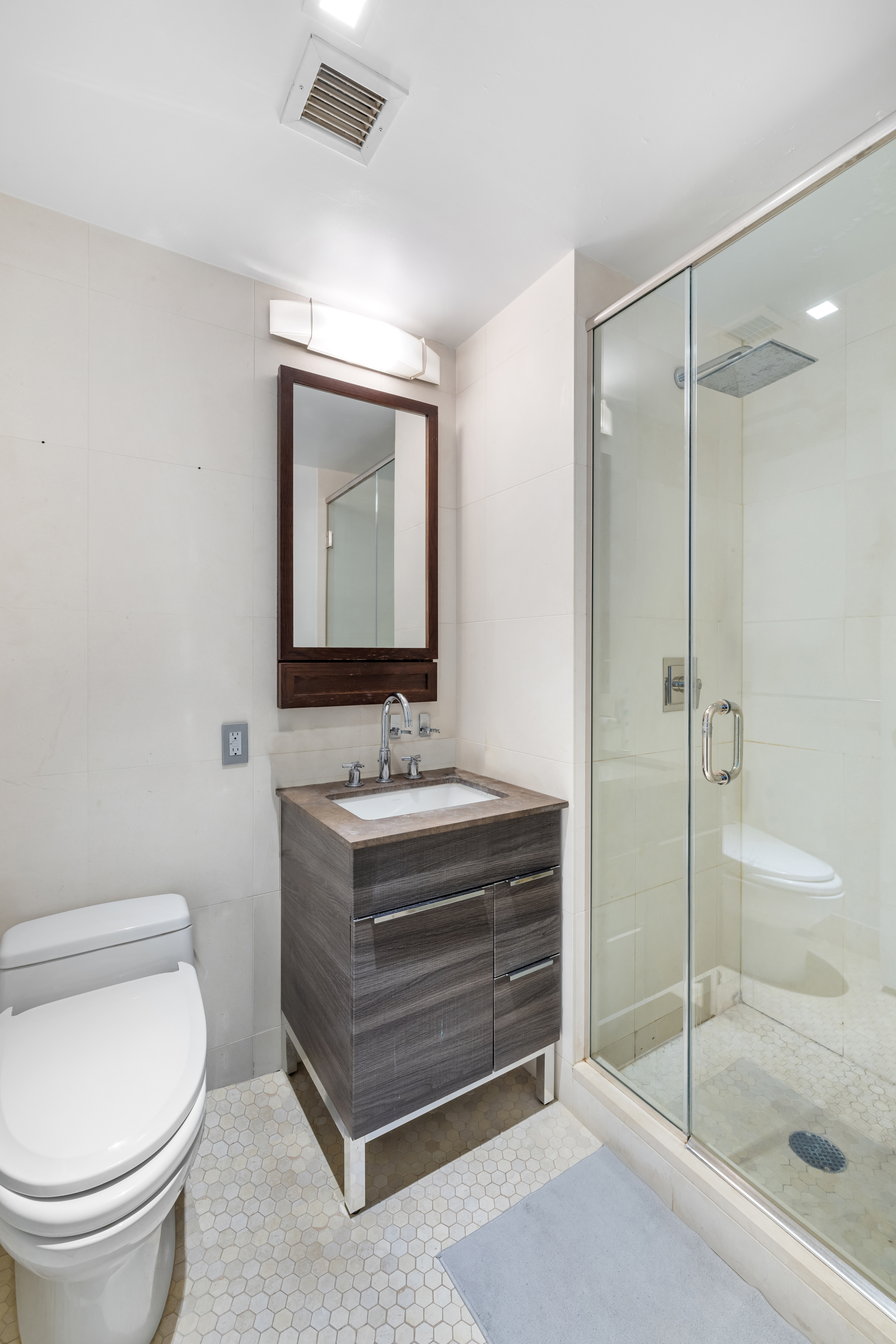 80 Riverside Boulevard, Unit 7E Manhattan, NY 10069 - Photo 9 of 12 a bathroom with a granite countertop sink toilet and shower