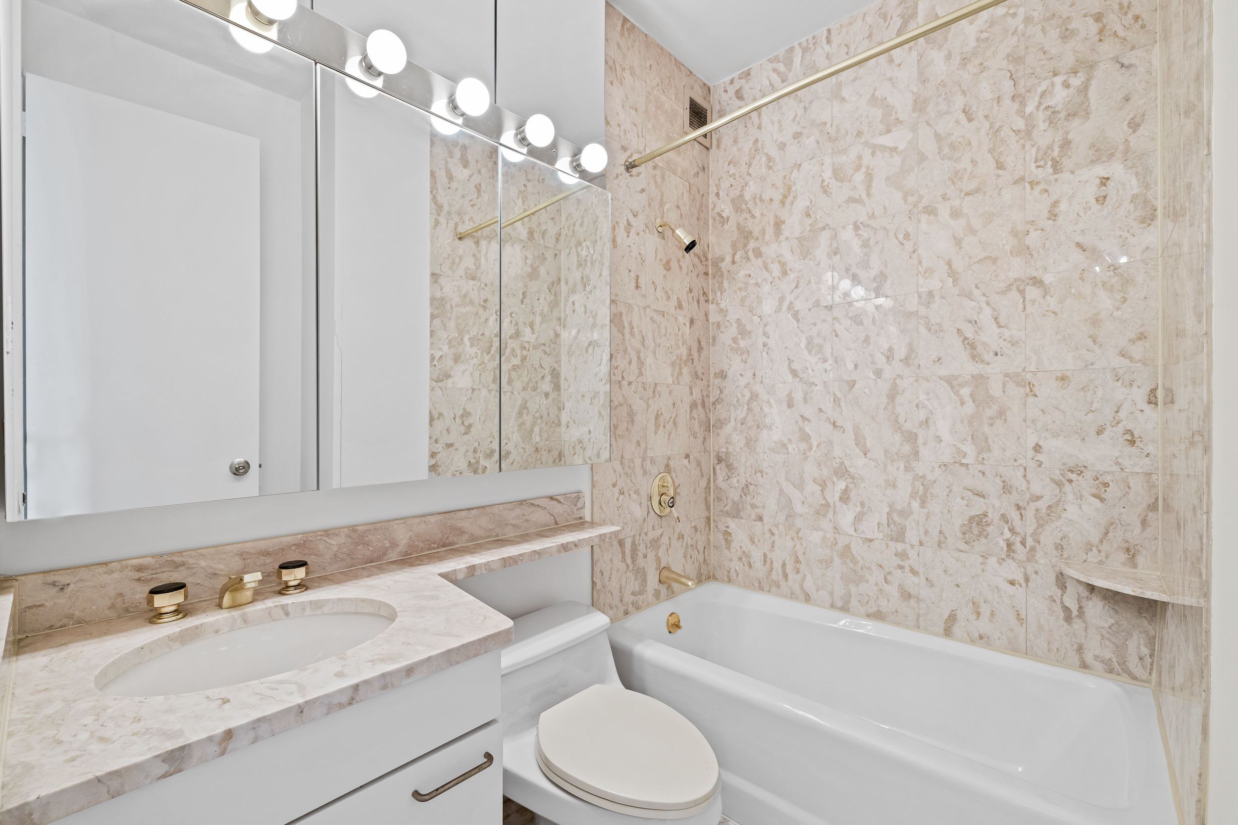 524 East 72nd Street, Unit 31AG Manhattan, NY 10021 - Photo 8 of 17 a bathroom with a granite countertop sink a toilet and bathtub