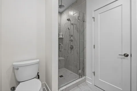 a bathroom with a shower a toilet and a sink