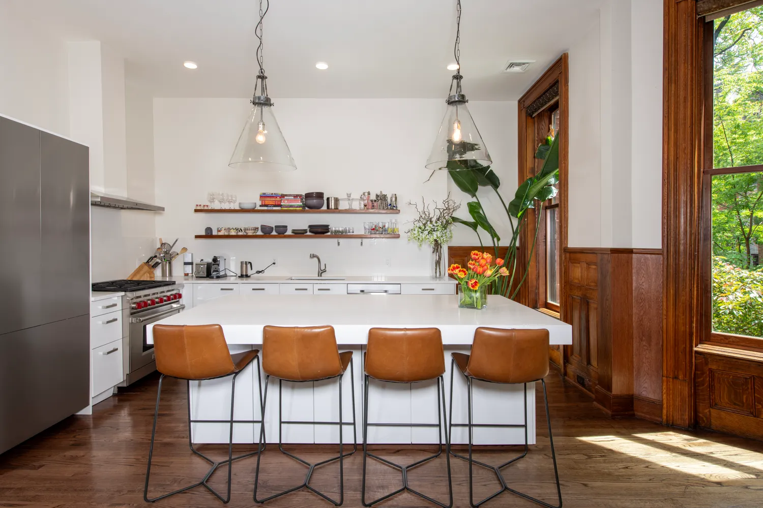 a kitchen with stainless steel appliances granite countertop a table and chairs in it