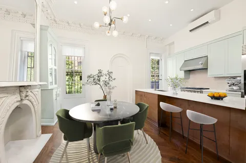 a kitchen with stainless steel appliances a table chairs and chandelier