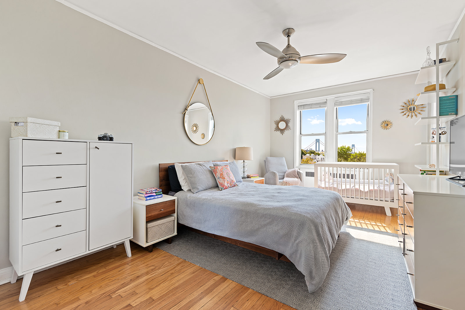 601 79th Street, Unit E12 Brooklyn, NY 11209 - Photo 5 of 8 a bedroom with a bed a chandelier and a dresser