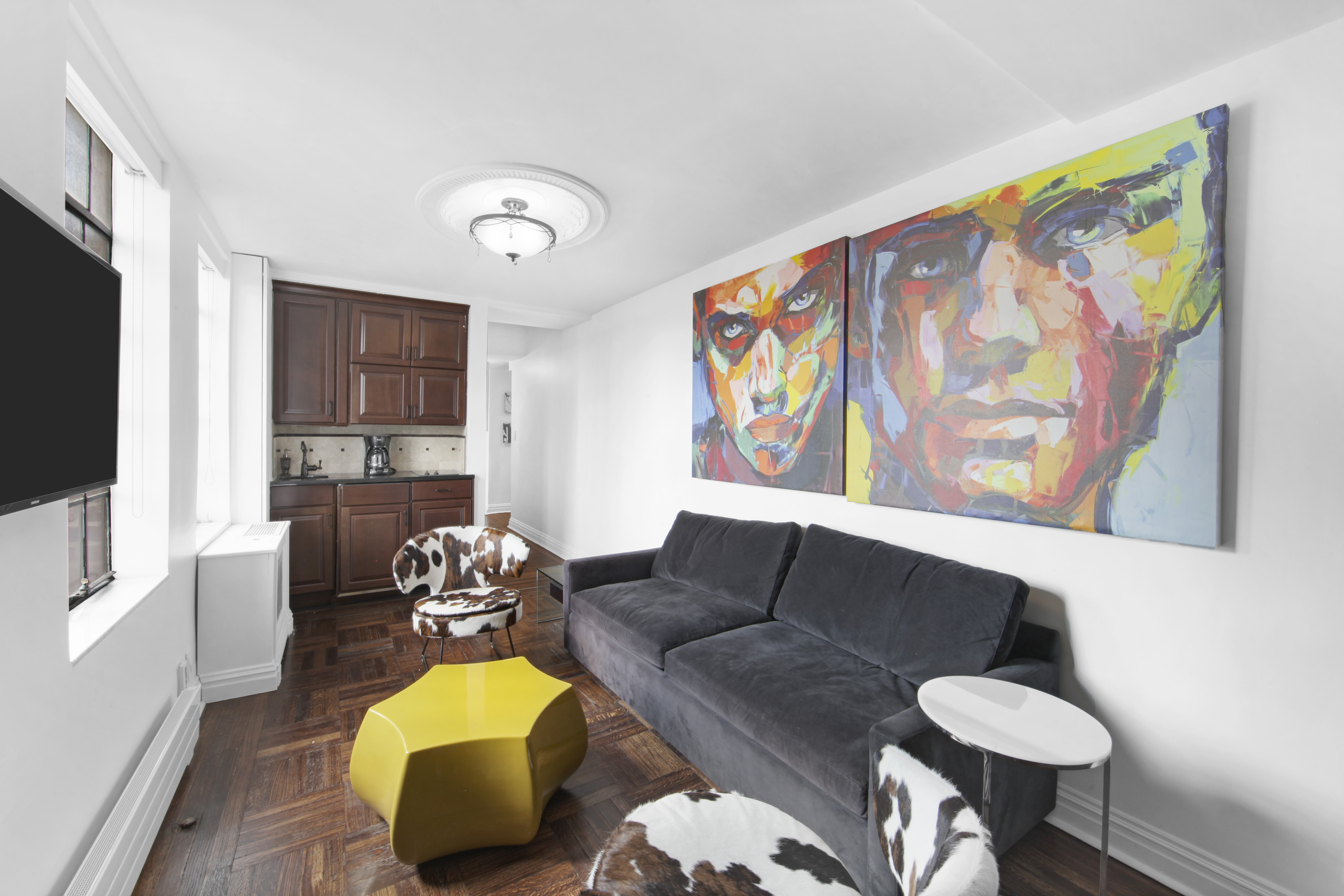 320 East 42nd Street, Unit 3012 Manhattan, NY 10017 - Photo 3 of 12 a living room with furniture and a flat screen tv