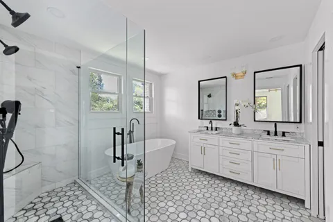 a white bath tub sitting in a bathroom next to a window