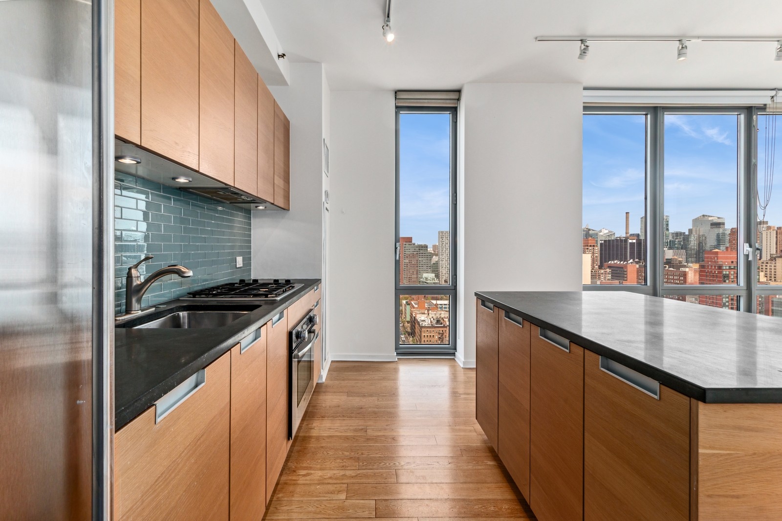 310 West 52nd Street, Unit 22H Manhattan, NY 10019 - Photo 5 of 12 a kitchen with stainless steel appliances granite countertop a sink and a stove