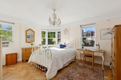 a bedroom with a bed chair and a window