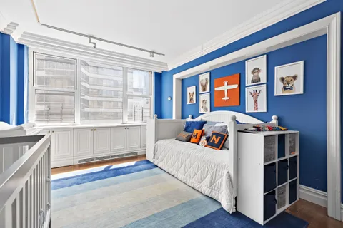 a bedroom with bed and a large window