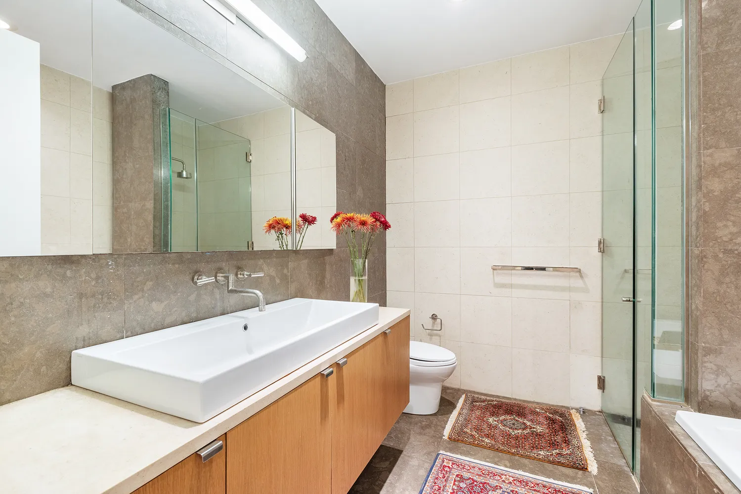 a bathroom with a sink a toilet a mirror and shower