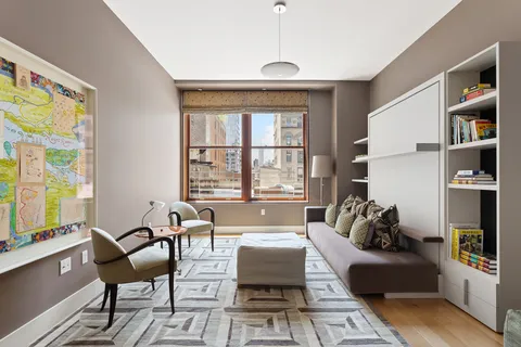 a living room with furniture a flat screen tv and a floor to ceiling window