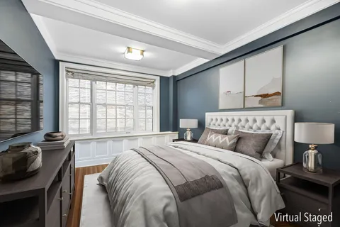 a bedroom with a bed a dresser next to a window