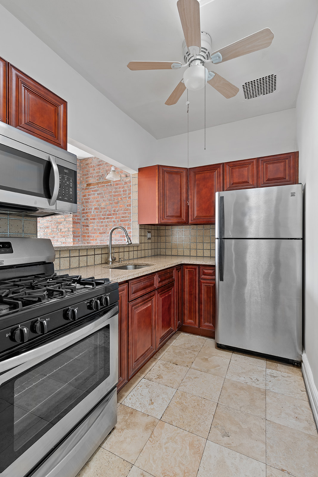 156 Bainbridge Street Brooklyn, NY 11233 - Photo 11 of 14 a kitchen with stainless steel appliances granite countertop a stove a refrigerator and a sink