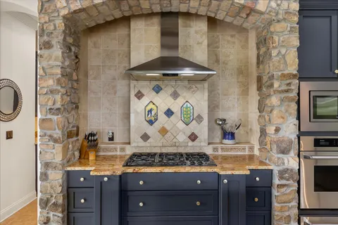 a bathroom with a granite countertop sink a stove and a shower