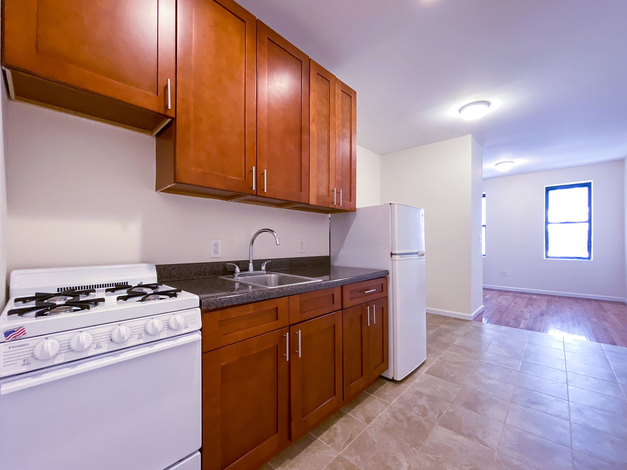 319 East 25th Street, Unit 3C Manhattan, NY 10010 - Photo 6 of 12 a kitchen with granite countertop a stove and a sink
