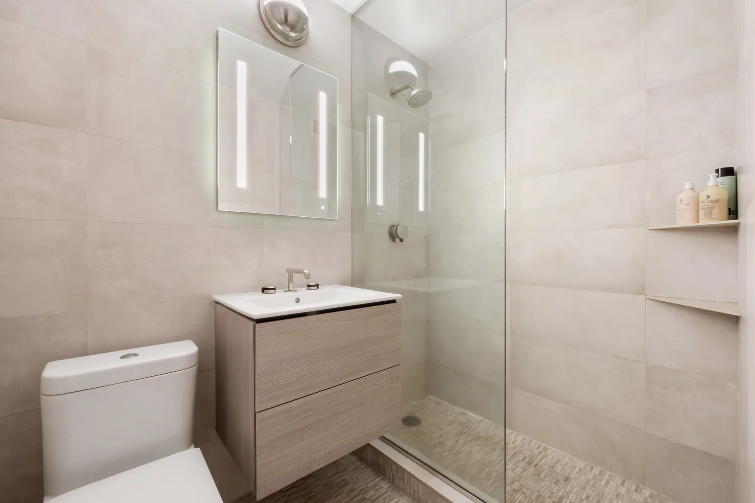 a bathroom with a sink a toilet and shower