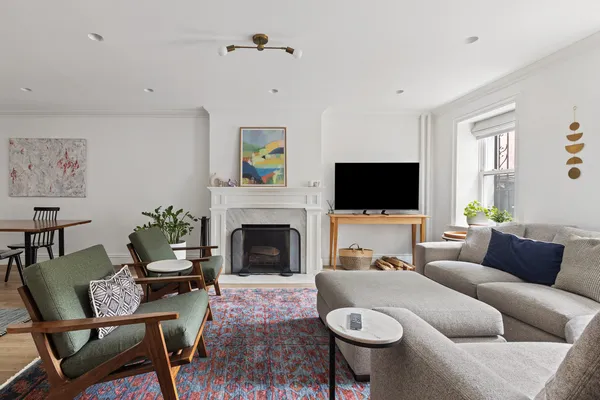 a living room with furniture a flat screen tv and a fireplace