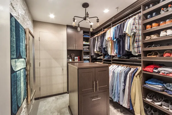 a view of walk in closet with clothes and shoes