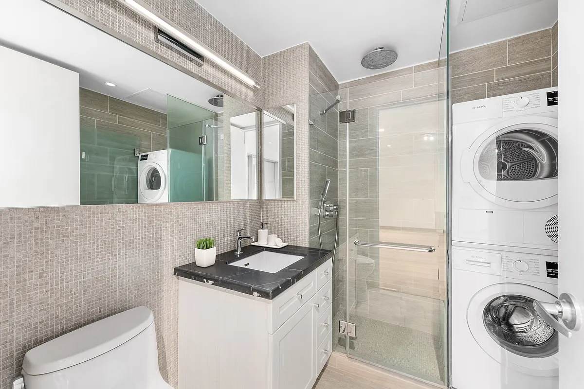 132 East 30th Street, Unit 2 Manhattan, NY 10016 - Photo 11 of 14 a bathroom with a sink a washer and dryer