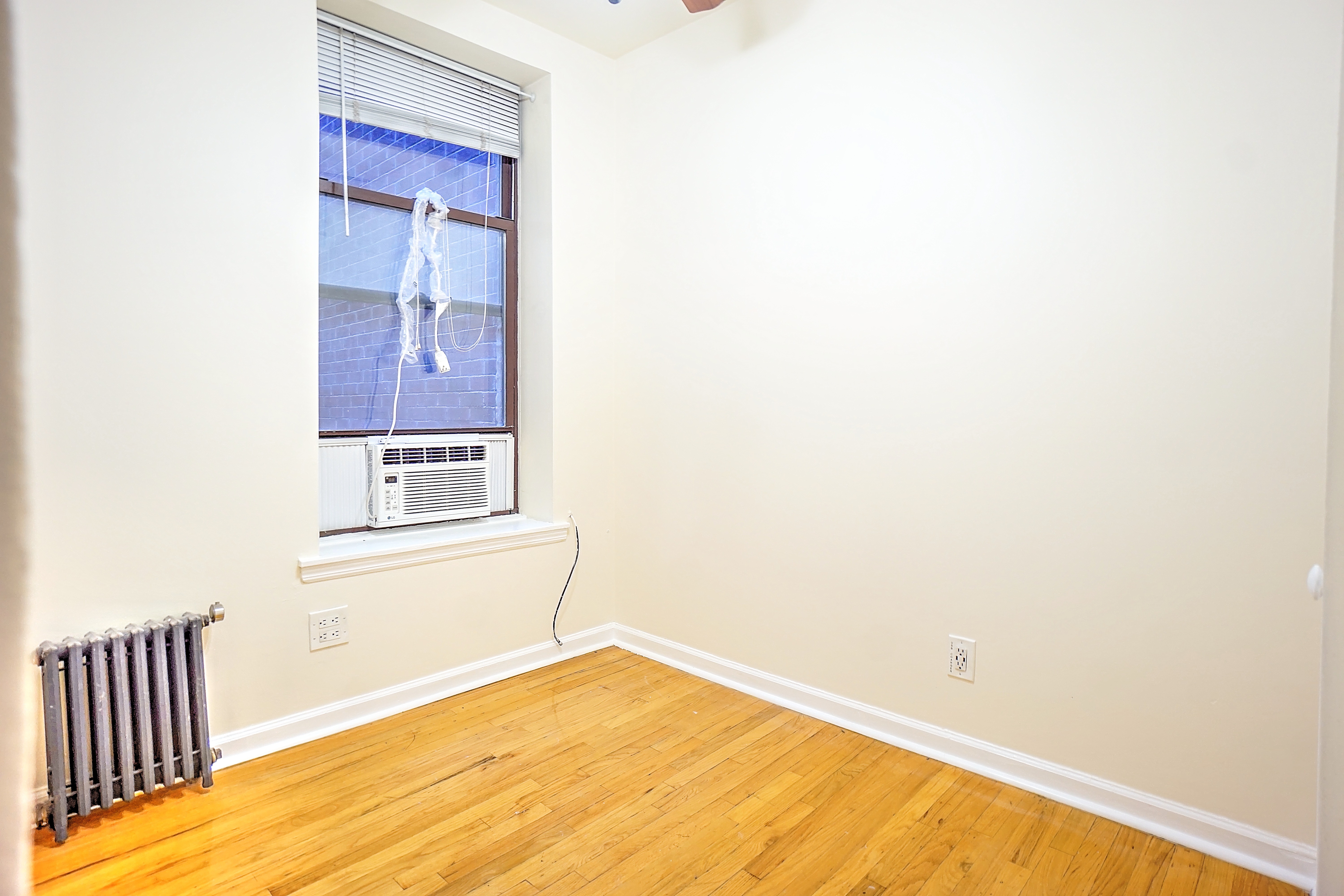 270 East 78th Street, Unit 10 Manhattan, NY 10075 - Photo 5 of 6 a view of a bedroom with wooden floor and a window