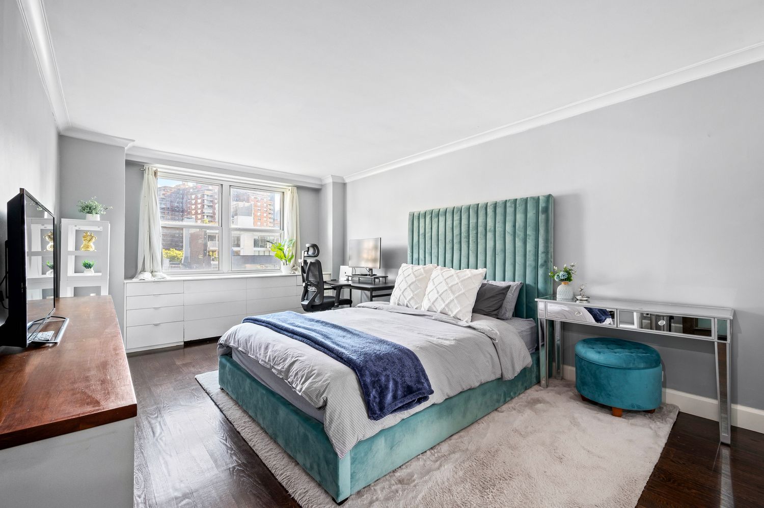 a bedroom with a large bed and a flat tv screen on a dresser