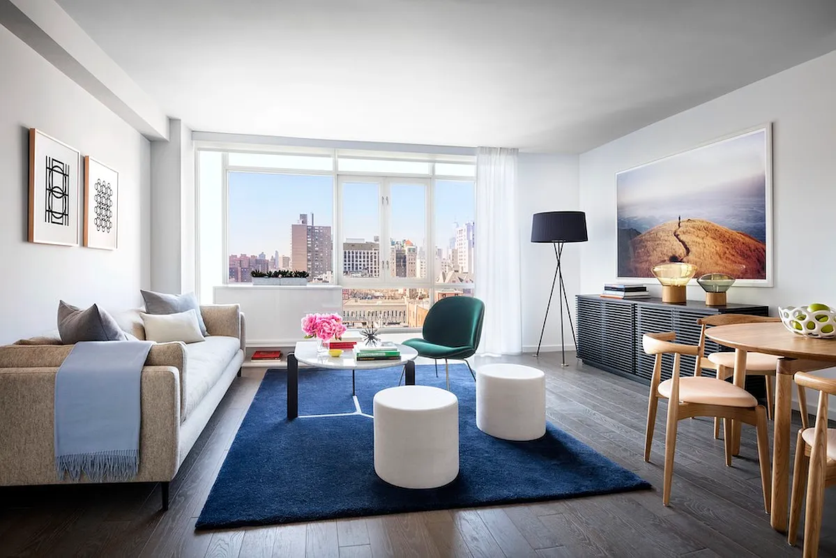 385 1st Avenue, Unit 11A Manhattan, NY 10010 - Photo 1 of 11 a living room with furniture and a large window