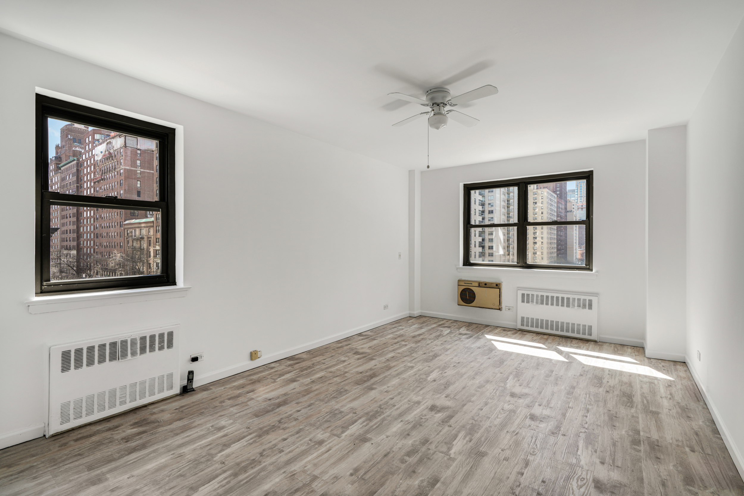 357 East 57th Street, Unit 5D Manhattan, NY 10022 - Photo 10 of 23 wooden floor in an empty room with a window