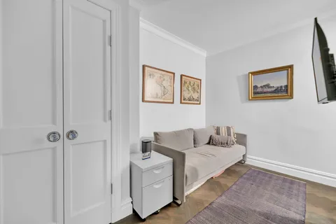 a living room with furniture and a wall painting