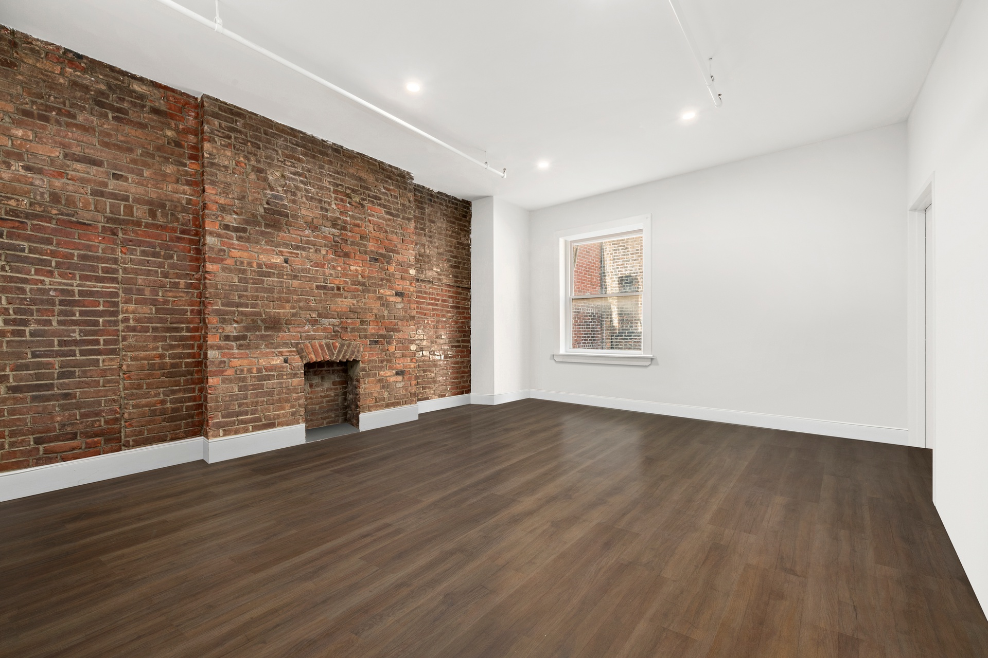 99 Spring Street, Unit PH Manhattan, NY 10012 - Photo 19 of 23 an empty room with wooden floor and fireplace