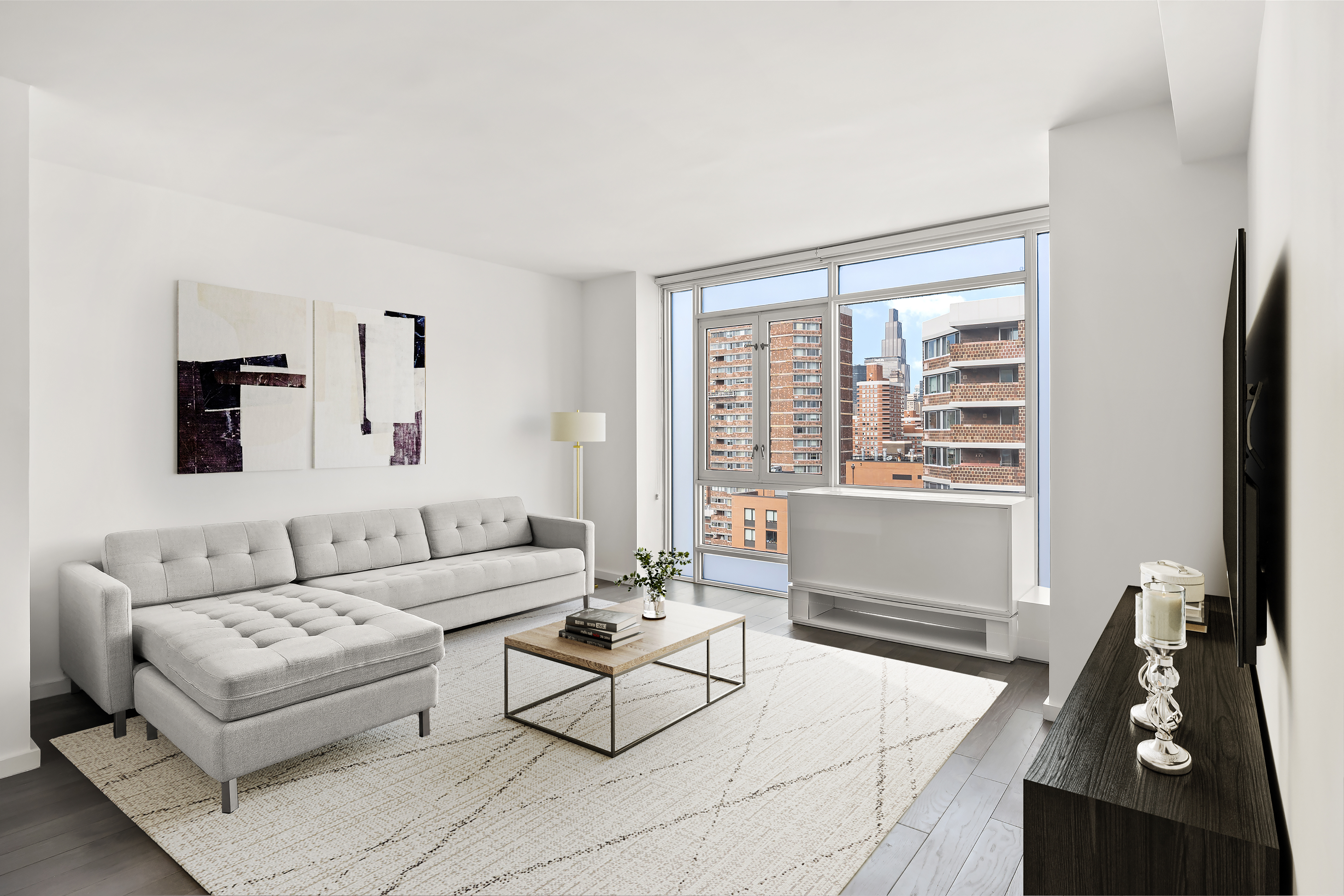 385 1st Avenue, Unit 20B Manhattan, NY 10010 - Photo 1 of 10 a living room with furniture and a flat screen tv