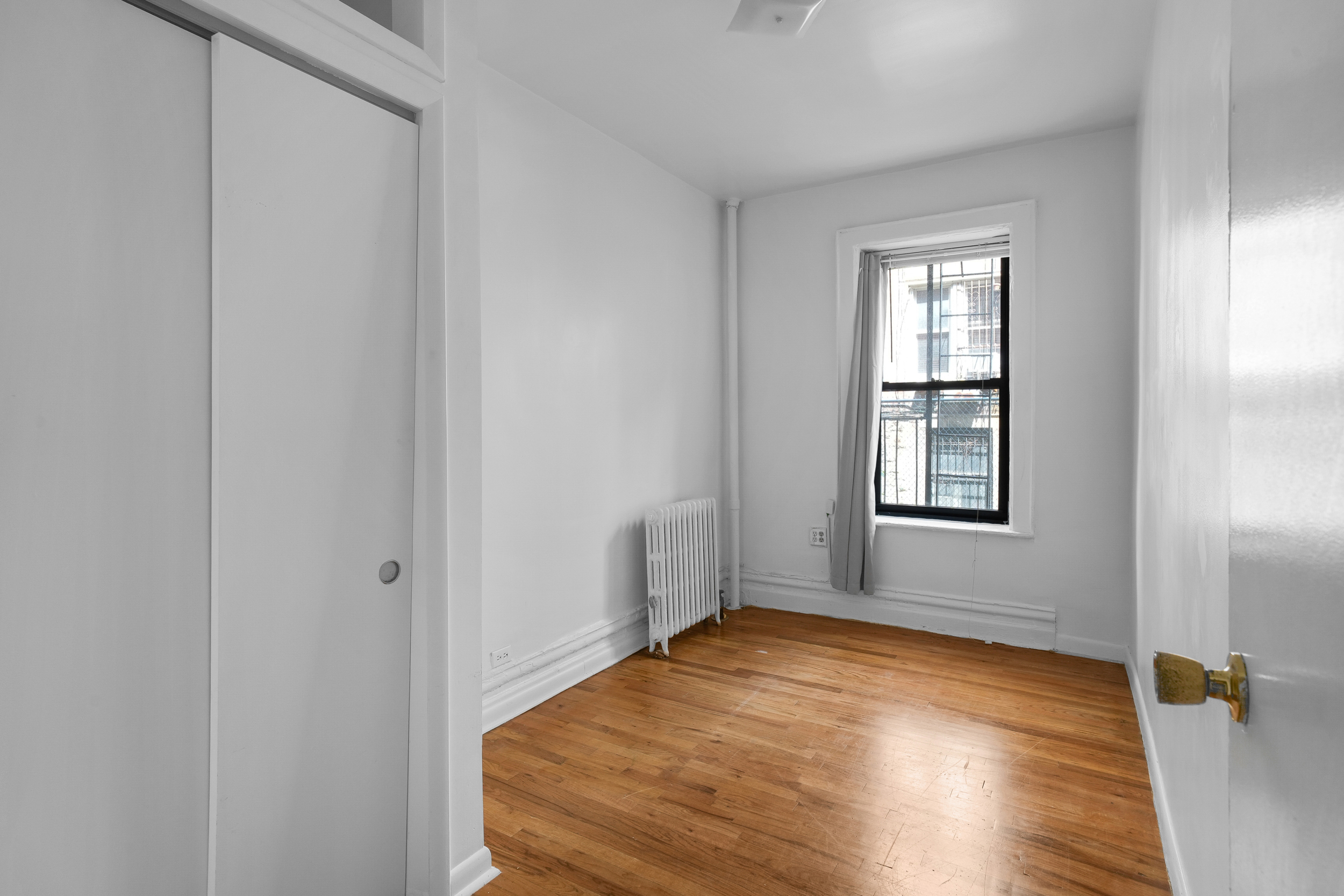 507 West 111th Street, Unit 3 Manhattan, NY 10025 - Photo 9 of 11 an empty room with wooden floor and windows
