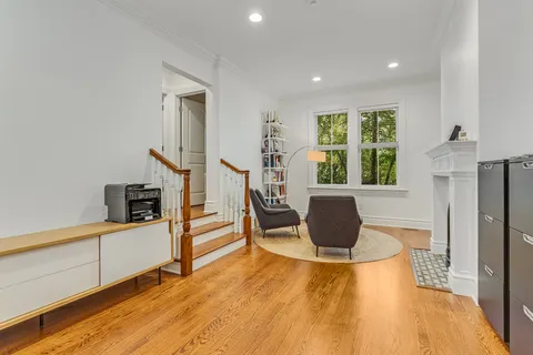 a view of a dining room with furniture a rug and wooden floor