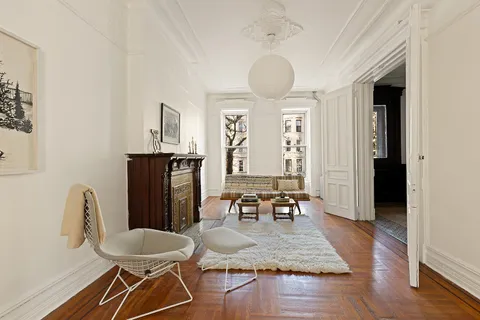 a living room with furniture a dining table and a refrigerator