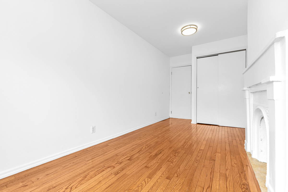 116 Ryerson Street Brooklyn, NY 11205 - Photo 10 of 16 a view of an empty room with wooden floor and a window