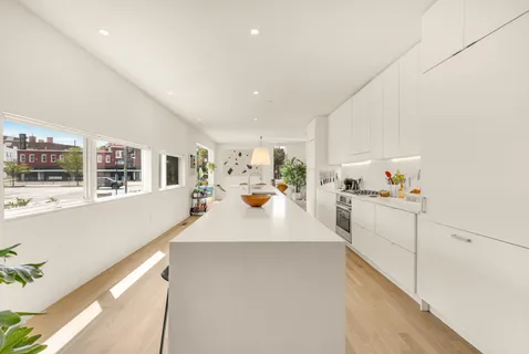 a large white kitchen with cabinets