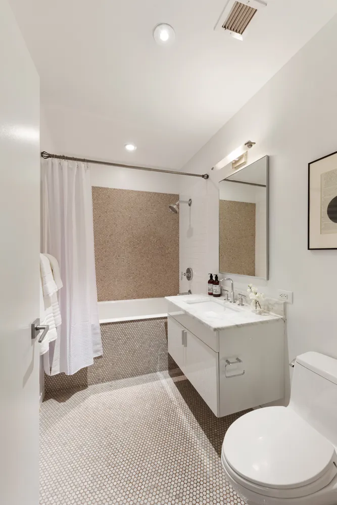 a bathroom with a sink a toilet and mirror