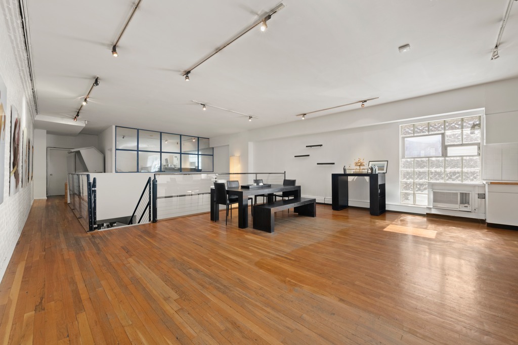 13 Worth Street, Unit 11 Manhattan, NY 10013 - Photo 5 of 9 a living room with furniture and kitchen view