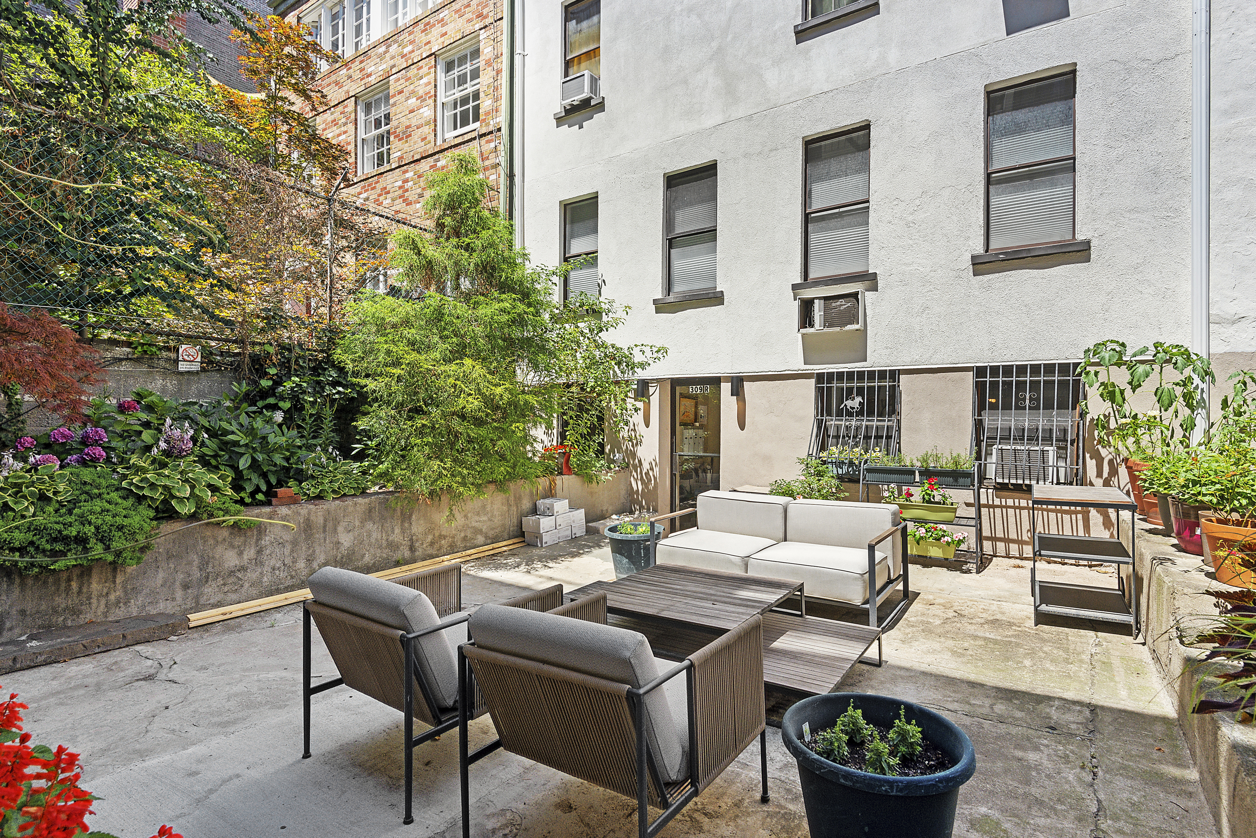 309 West 20th Street, Unit 1R Manhattan, NY 10011 - Photo 9 of 10 a view of a patio with couches table and chairs and potted plants