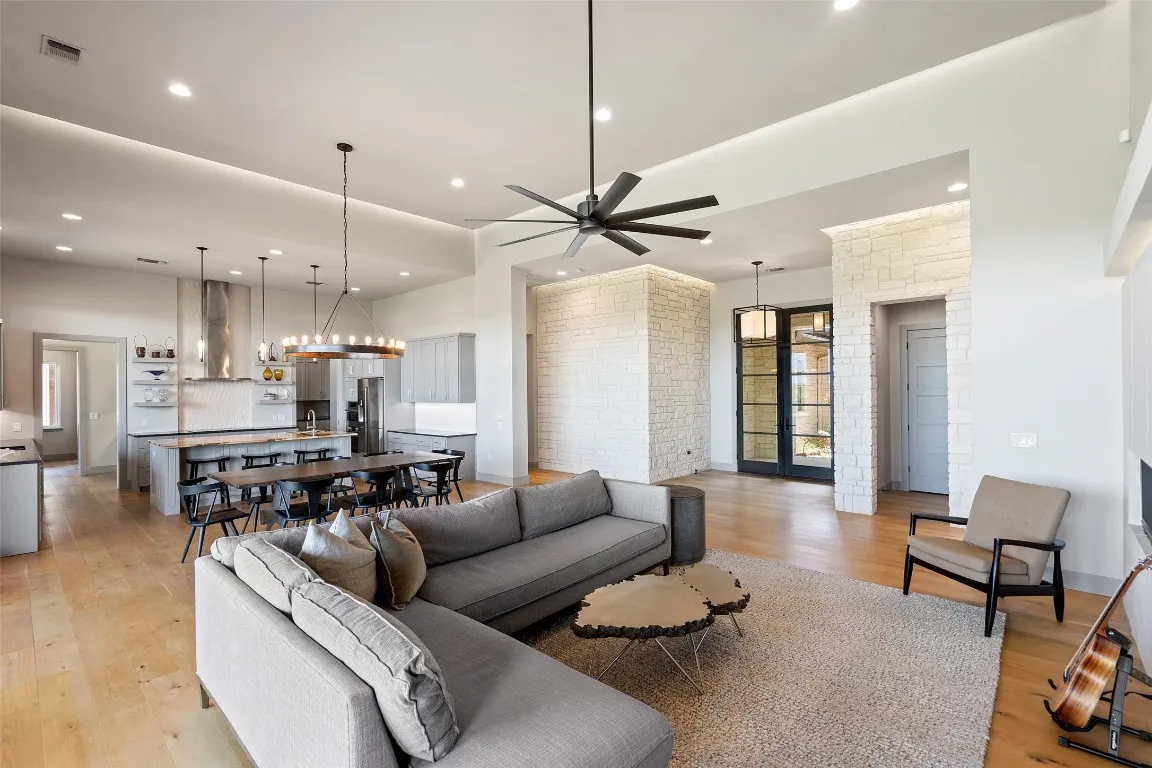 a living room with furniture kitchen view and a chandelier